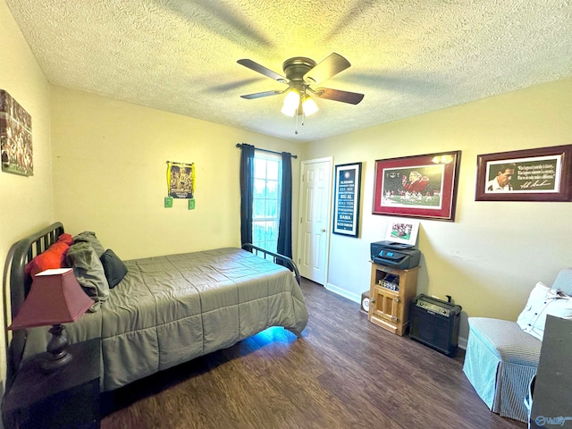 bedroom with a textured ceiling, ceiling fan, and dark wood-type flooring