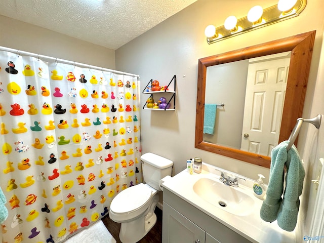 bathroom with vanity, hardwood / wood-style flooring, toilet, a textured ceiling, and curtained shower