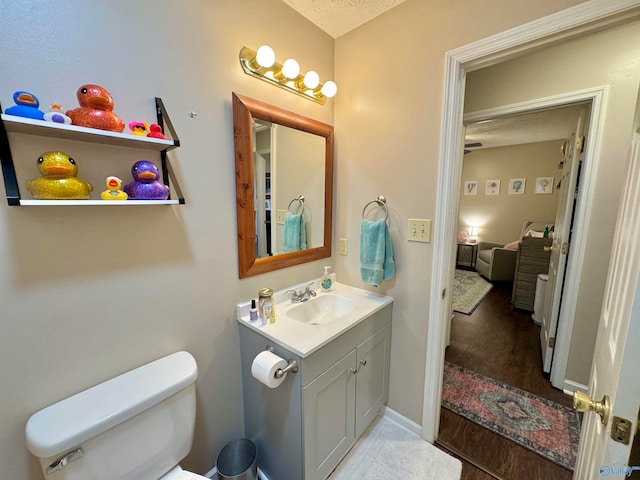 bathroom with vanity, toilet, and a textured ceiling