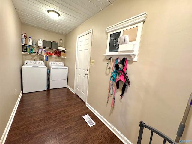 clothes washing area featuring dark hardwood / wood-style flooring, washer and clothes dryer, and wooden ceiling