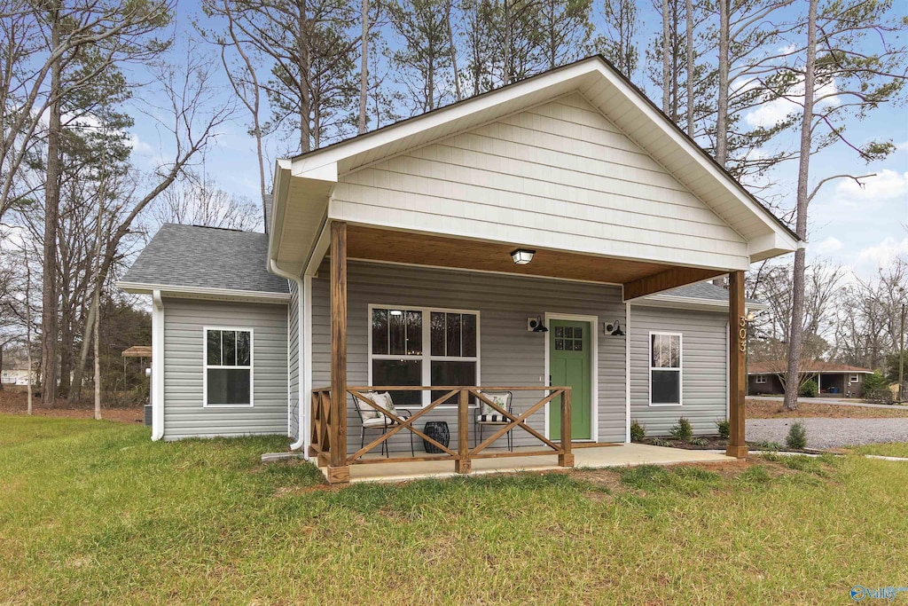 view of front of property featuring covered porch and a front yard