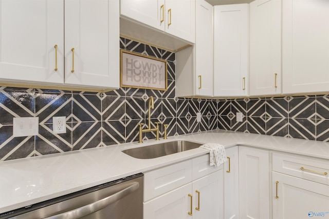 kitchen featuring backsplash, stainless steel dishwasher, sink, and white cabinets