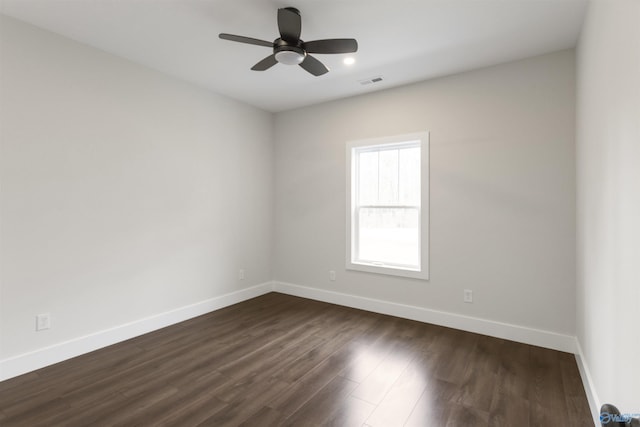 spare room with dark wood-type flooring and ceiling fan