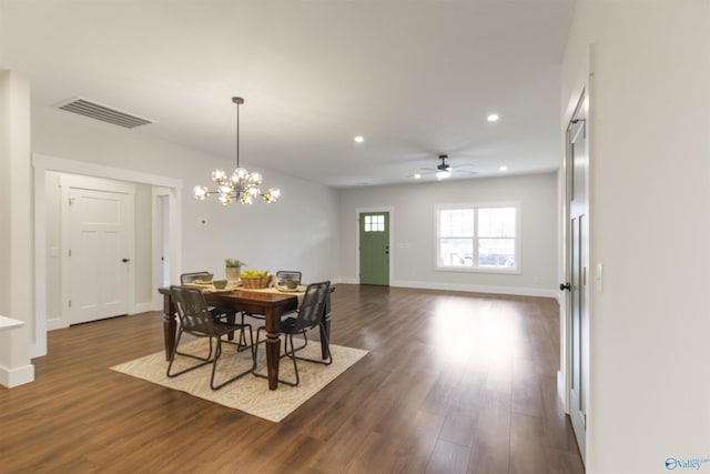 dining space featuring ceiling fan with notable chandelier and dark wood-type flooring