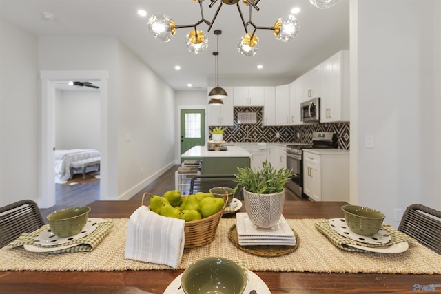 kitchen featuring white cabinetry, tasteful backsplash, dark hardwood / wood-style flooring, pendant lighting, and stainless steel appliances