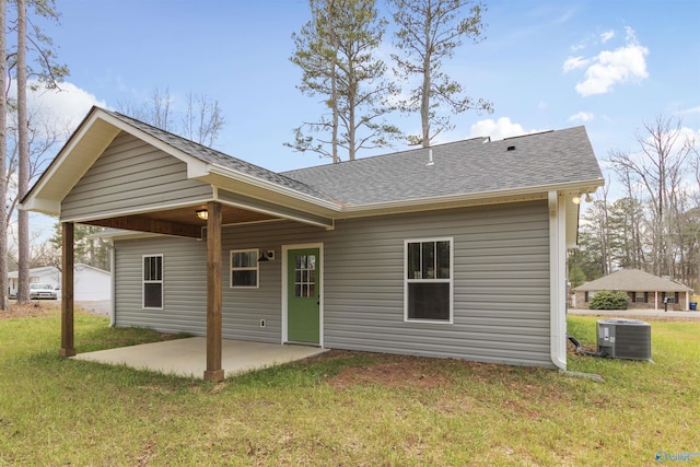 rear view of property with central AC unit, a yard, and a patio