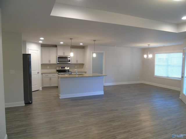 kitchen featuring dark wood-type flooring, baseboards, open floor plan, recessed lighting, and appliances with stainless steel finishes