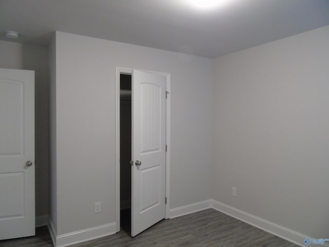 unfurnished bedroom featuring baseboards and dark wood-style flooring