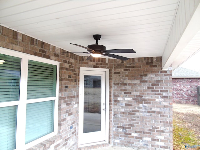 entrance to property with brick siding and ceiling fan