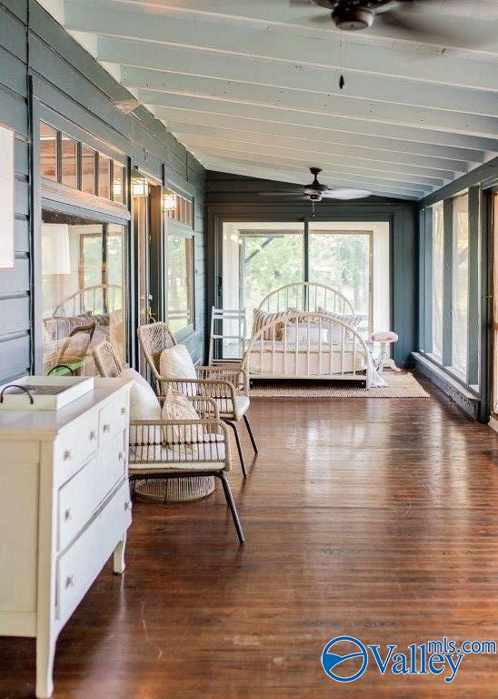 sunroom with ceiling fan and beam ceiling