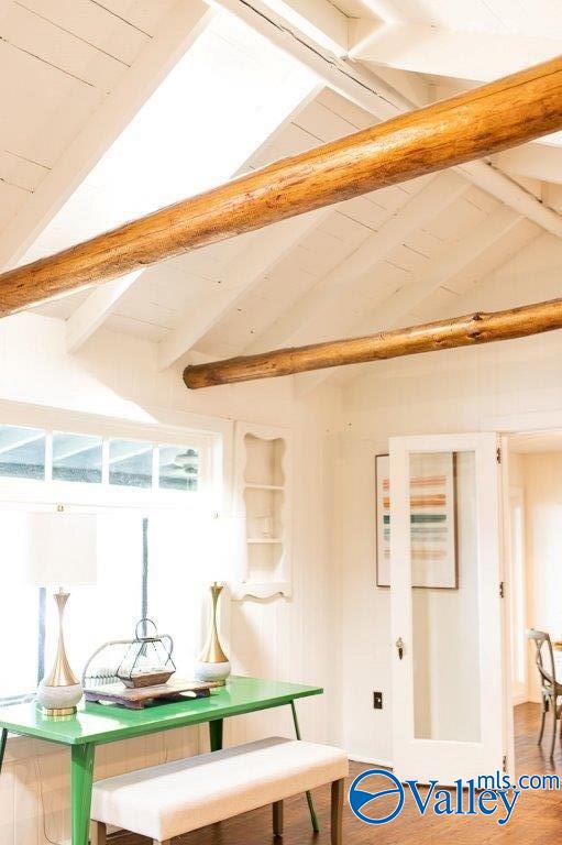 interior space featuring hardwood / wood-style flooring and vaulted ceiling with beams