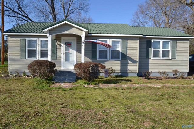 view of front of home with metal roof and a front yard