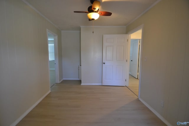 corridor featuring light wood-style flooring, baseboards, and ornamental molding