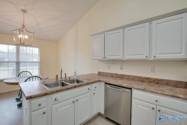 kitchen with lofted ceiling, a peninsula, a sink, white cabinetry, and dishwasher