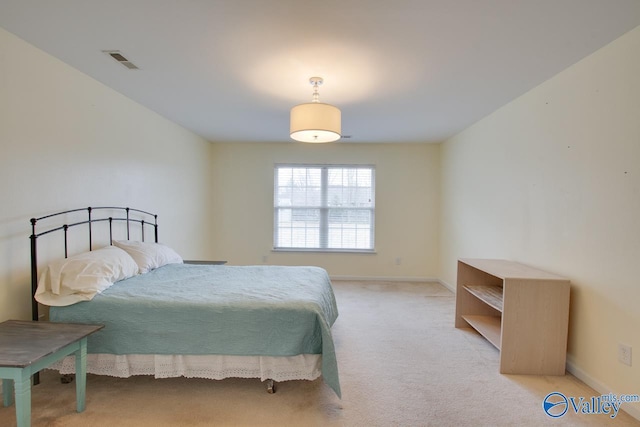 bedroom featuring baseboards, visible vents, and light colored carpet