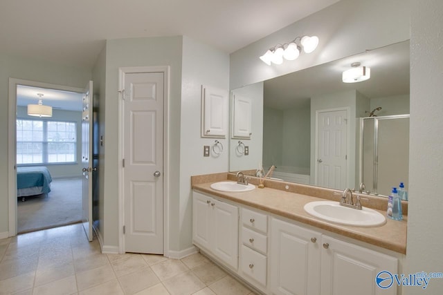 full bath featuring a stall shower, tile patterned flooring, a sink, and double vanity