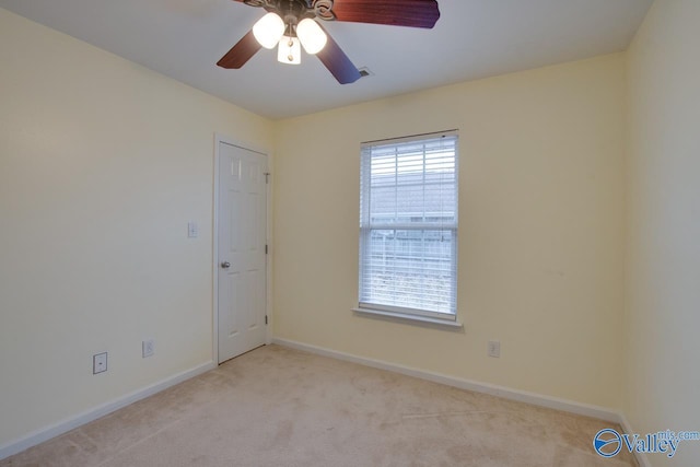 carpeted spare room with baseboards and a ceiling fan