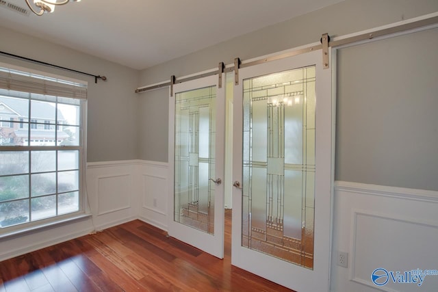 doorway featuring a healthy amount of sunlight, a barn door, and visible vents