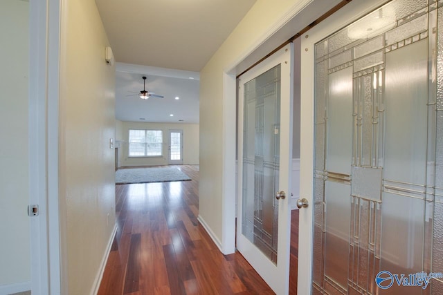 corridor featuring wood finished floors and baseboards