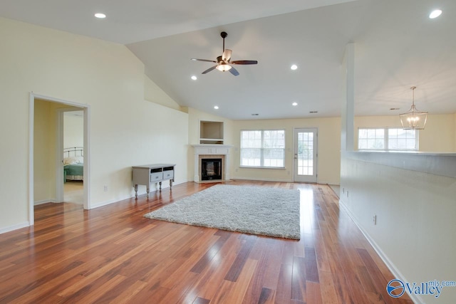 unfurnished living room featuring a fireplace with flush hearth, recessed lighting, baseboards, and wood finished floors