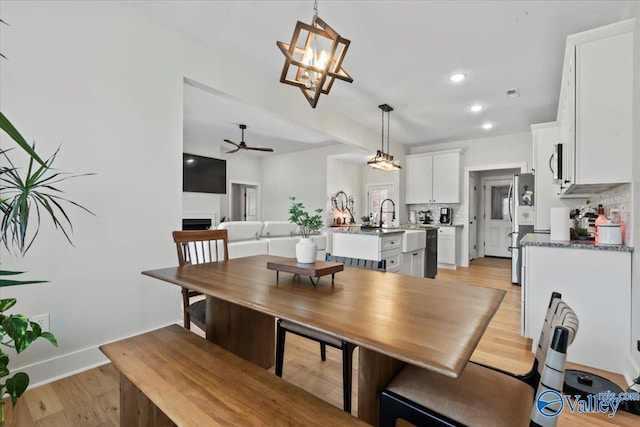 dining room featuring light wood-type flooring, baseboards, ceiling fan with notable chandelier, visible vents, and recessed lighting
