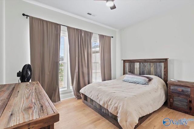 bedroom with visible vents, light wood-style flooring, and a ceiling fan