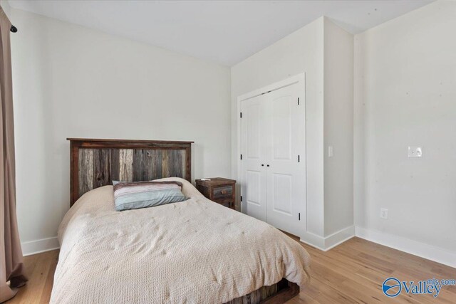 bedroom featuring a closet, baseboards, and wood finished floors