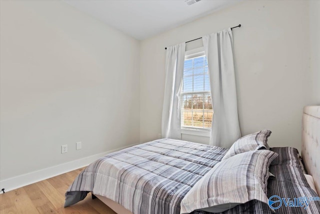 bedroom with baseboards and wood finished floors