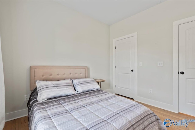 bedroom with baseboards and light wood-type flooring