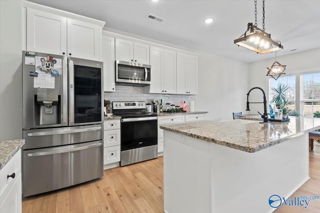 kitchen featuring decorative backsplash, light wood-style flooring, visible vents, appliances with stainless steel finishes, and a sink