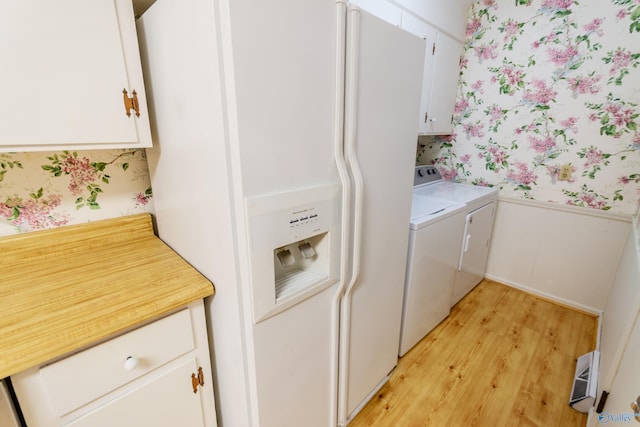 laundry room with light hardwood / wood-style flooring, cabinets, and independent washer and dryer