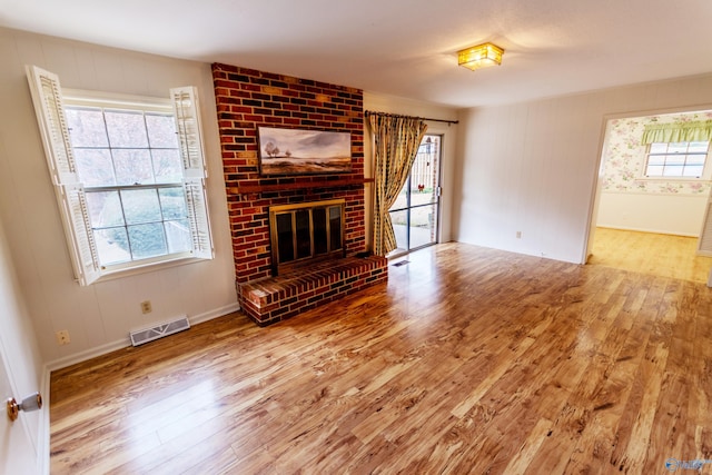 unfurnished living room featuring hardwood / wood-style floors, plenty of natural light, and a fireplace