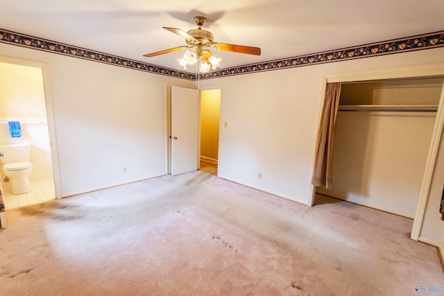 unfurnished bedroom with ensuite bath, ceiling fan, a closet, and light carpet