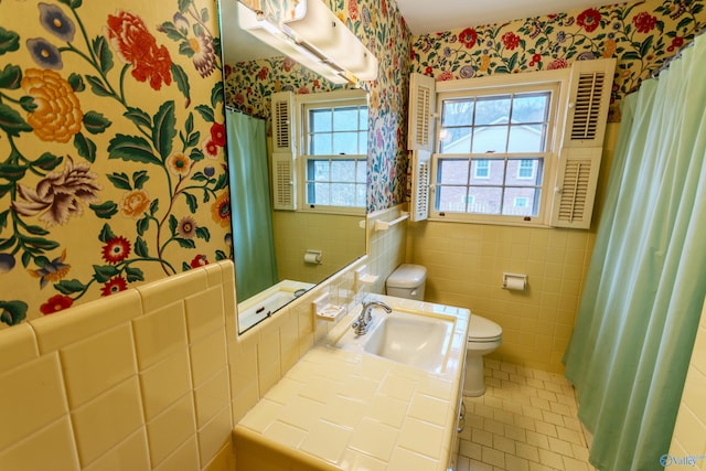 bathroom with tile patterned floors, vanity, toilet, and tile walls