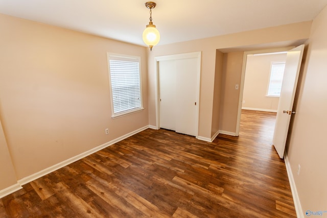 unfurnished bedroom with a closet and dark hardwood / wood-style flooring