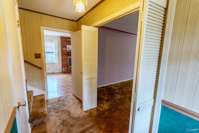 corridor with carpet flooring, an inviting chandelier, and ornamental molding