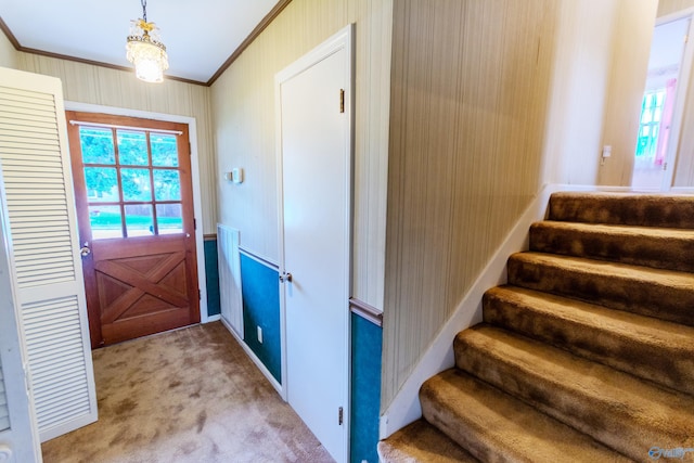 doorway to outside with carpet flooring and crown molding