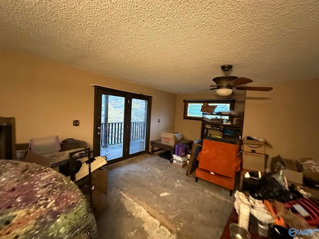 interior space featuring ceiling fan, concrete flooring, and a textured ceiling