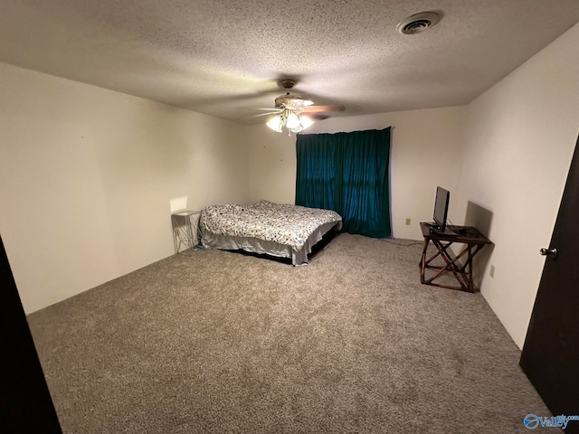 bedroom with a textured ceiling, carpet floors, and ceiling fan