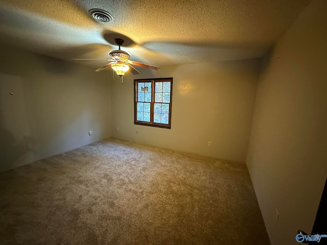 carpeted empty room with a textured ceiling and ceiling fan