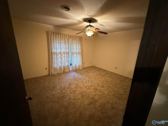 empty room featuring carpet flooring, a textured ceiling, and ceiling fan