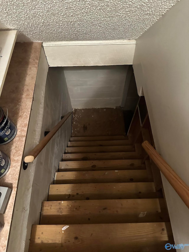 staircase with a textured ceiling