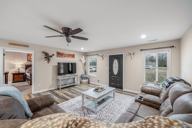 living room featuring light wood-style flooring, recessed lighting, and baseboards