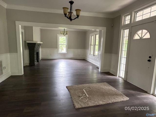 2494 Hines St S, Athens, AL 35611 - foyer entrance featuring a chandelier, wainscoting, dark wood-style floors, crown molding, and a brick fireplace