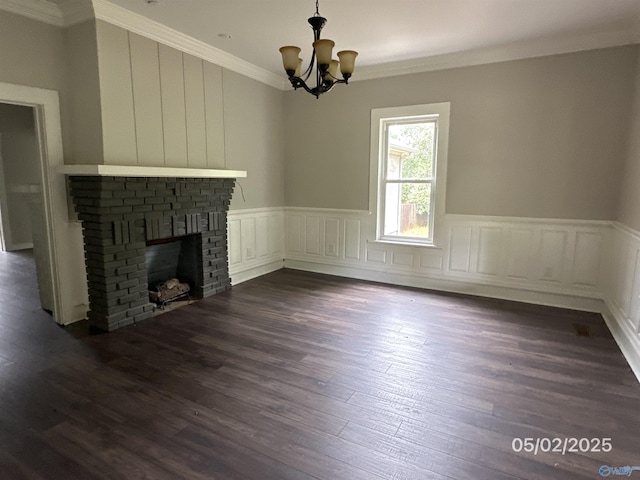2494 Hines St S, Athens, AL 35611 - unfurnished living room with ornamental molding, a chandelier, dark wood-style flooring, a brick fireplace, and wainscoting