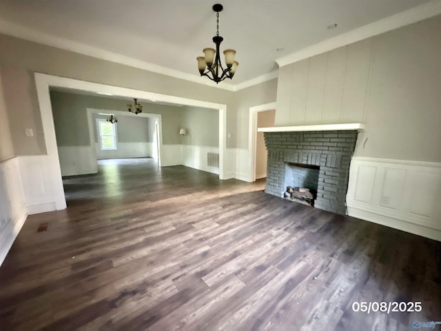 2494 Hines St S, Athens, AL 35611 - unfurnished living room featuring a chandelier, ornamental molding, a brick fireplace, wainscoting, and a decorative wall
