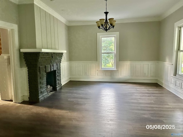 2494 Hines St S, Athens, AL 35611 - unfurnished living room featuring a chandelier, dark wood-style flooring, crown molding, a fireplace, and a wainscoted wall