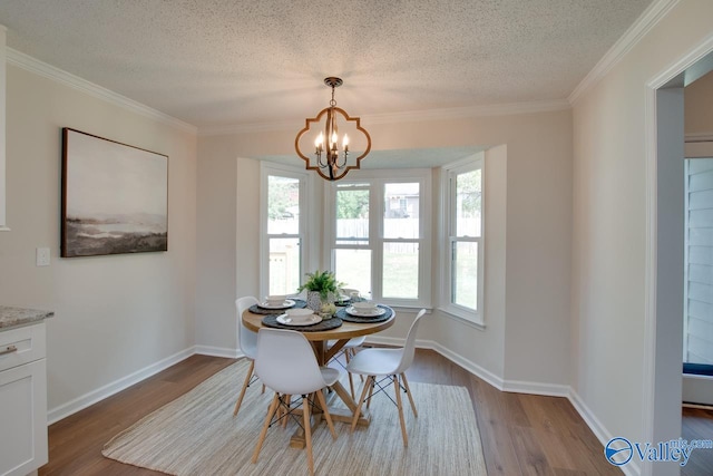 dining area featuring light wood-style floors, a notable chandelier, a textured ceiling, and baseboards