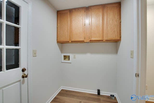 clothes washing area featuring light wood-style flooring, washer hookup, cabinet space, and baseboards