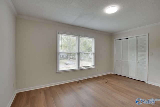 15011 Glory Dr SE, Huntsville, AL 35803 - unfurnished bedroom with wood finished floors, a textured ceiling, a closet, and ornamental molding